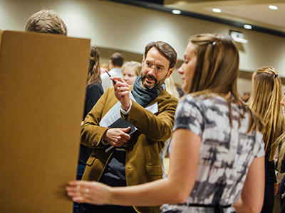 A student and professor at the academic info fair.