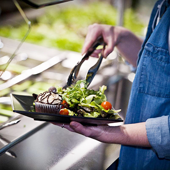 person serving food onto their plate