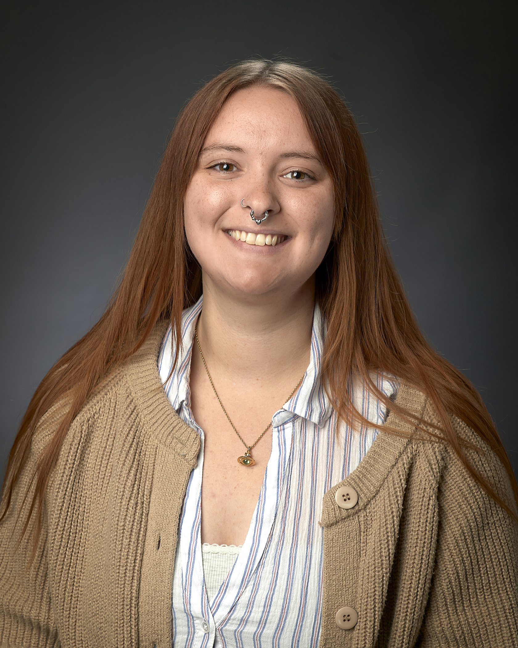 Image of smiling caucasian female in light colored shirt and cardigan.