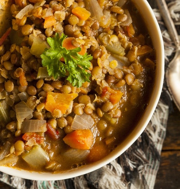 An image of slow cooker lentil soup in a white bowl.