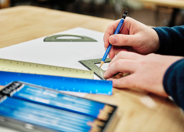 someone doing homework with a ruler