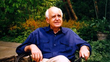 Man in blue shirt seated in patio chair